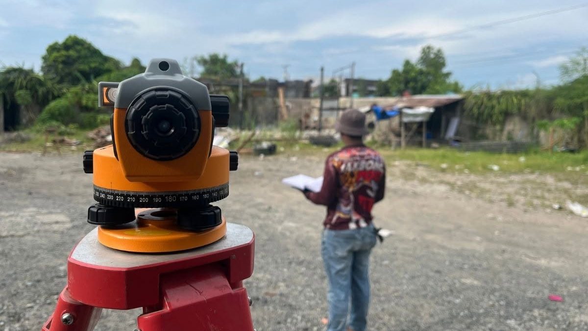 Automatic level set up on site while a team member records measurements