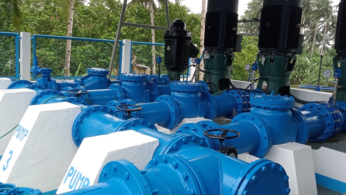 Pump station with blue pipe manifold and vertical pumps